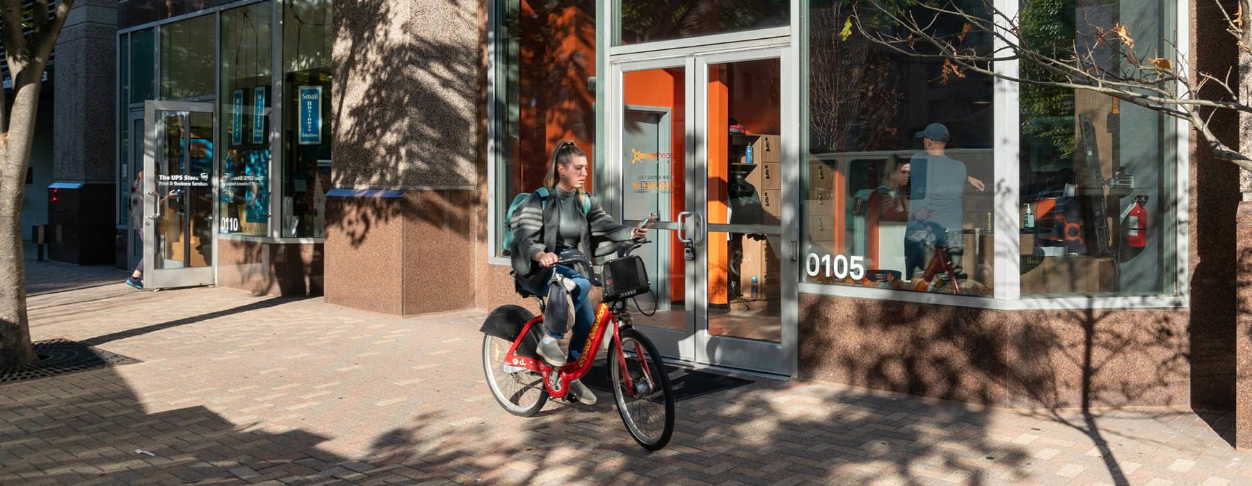 Woman Riding A Bike By Orange Theory Fitness Near J Sol Apartments In Arlington, VA